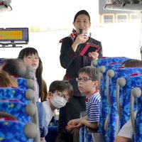 成田空港を巡るツアーで客室乗務員が出題するクイズを楽しむ参加者