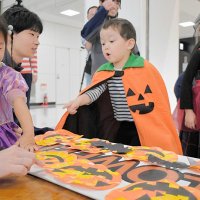 成田空港でハロウィーンのコスチュームを身にまとい、地上係員と装飾を楽しむ子どもたち＝２２日、成田市