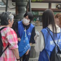 成田山新勝寺を訪れた外国人観光客に英語で案内活動を行う城西国際大観光学部の学生（左から２人目）ら＝１日、成田市