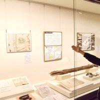 館山市立博物館では、過去の発掘資料などとともに館山城跡の絵図の写真パネルを展示している＝館山市