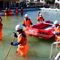 とび口で水中を確認し、ボートを押す消防団員＝２４日、茂原市