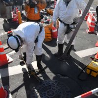 マンホールのふたを開け、点検を開始する作業員＝３１日午後、松戸市栗山