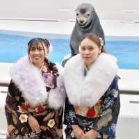“笑うアシカ”の「カンジ」と一緒に笑顔を浮かべる「二十歳の集い」の参加者＝１２日、鴨川市