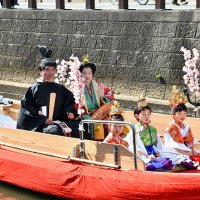 川岸の観光客に手を振る久保木さん夫婦