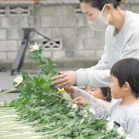 花を手向ける親子＝１１日、旭市