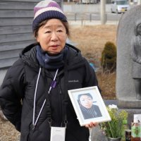 津波で亡くした健太さんの写真を手に、命の大切さを訴える田村弘美さん＝２月１２日、宮城県女川町（敬愛大学提供）