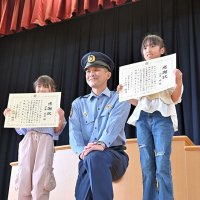 迷子の女の子を助け、感謝状を受け取った伊藤さん（左）と渋井さん（右）＝１４日、八千代市緑が丘の市立新木戸小学校