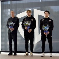 市職員から受け取った花束を手に初優勝と１部昇格を報告するアルティーリ千葉の大塚主将（中央）と黒川選手（右）、レマニス監督＝２８日、千葉市役所