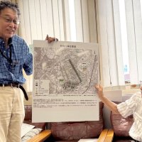 かつて存在した陸軍柏飛行場の位置を現在の地図に重ね合わせて説明する柏歴史クラブの上山代表（右）と桜井良樹副代表