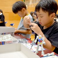 ガンダムのプラモデルを真剣に組み立てる児童＝成田市
