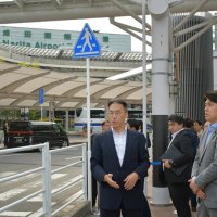 成田空港の乗降場を視察し、白タク行為やハイヤー運転手の客引きなどの対策について説明を受ける中野国交相（手前右）＝２２日、成田市
