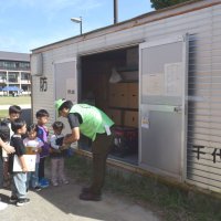 スタンプシールラリーでみどりが丘小の校内に設置された防災倉庫を巡る親子ら