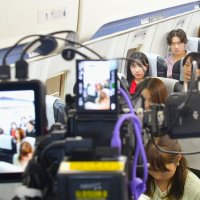 成田空港を題材にしたショートドラマで旅客機内の模型の中で撮影される出演者ら＝芝山町の航空科学博物館