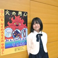 最優秀作品を用いたポスターと制作した葛生さん