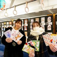 展示＆プレゼント企画に使用される多彩なデザインの年賀状を手にする学生＝大多喜町