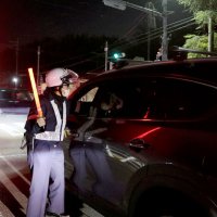 信号待ちの車の運転者に呼気検査をする市原署員