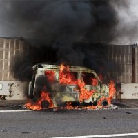 東関道下りの車線脇で炎上する車＝１５日午後１時５５分ごろ、船橋市