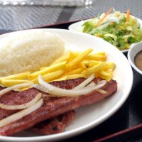 味付けされたリングイッサ（左皿の肉）をメインに、インゲン豆のスープ「フェイジョン」（右）も付いた定食