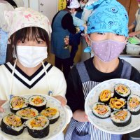 完成した太巻きずしを披露する児童