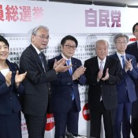 当確者の名前にバラを付け、拍手する自民党の（左から）有村総務会長、古屋選対委員長、松山参院議員会長、鈴木幹事長、石井参院幹事長、小林政調会長＝８日午後８時３５分、東京・永田町の党本部（共同）
