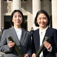 国会議事堂前で写真撮影する参政の中谷、工藤両衆院議員＝１８日午前、東京都千代田区