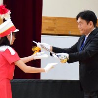 指揮杖を内田校長に返還する主指揮の吉野さん
