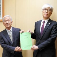 機能強化の用地取得に関する提言書をＮＡＡの藤井社長（右）に手渡す有志の会の山崎会長＝８日、成田市
