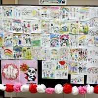 駅改札前に展示された地元の子どもたちが描いた「家族の似顔絵」