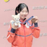 プレゼントされたチワワのぬいぐるみと銅メダルを掲げて笑顔を見せる中井選手＝流山市