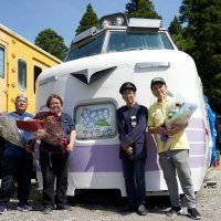 ライラックの車両と記念撮影に応じる、保存会メンバーとポッポの丘代表の村石さん（右）。愛称幕には「ライラック」の表示＝いすみ市