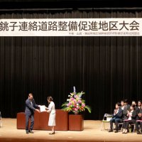 銚子連絡道路整備推進地区大会で要望書を手渡す米本会長（中央左）＝２０日、旭市の県東総文化会館