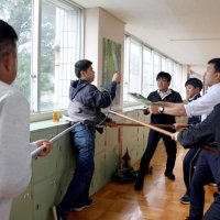 不審者に扮（ふん）した同署員を刺股などを使って取り押さえる教職員ら＝山武市