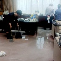 腐食した配管のあった市長室で漏れ出した水を片付ける照川市長ら＝２８日、勝浦市役所