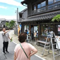 観光客に菖蒲葺きの由来などを説明する松本さん＝４日、香取市